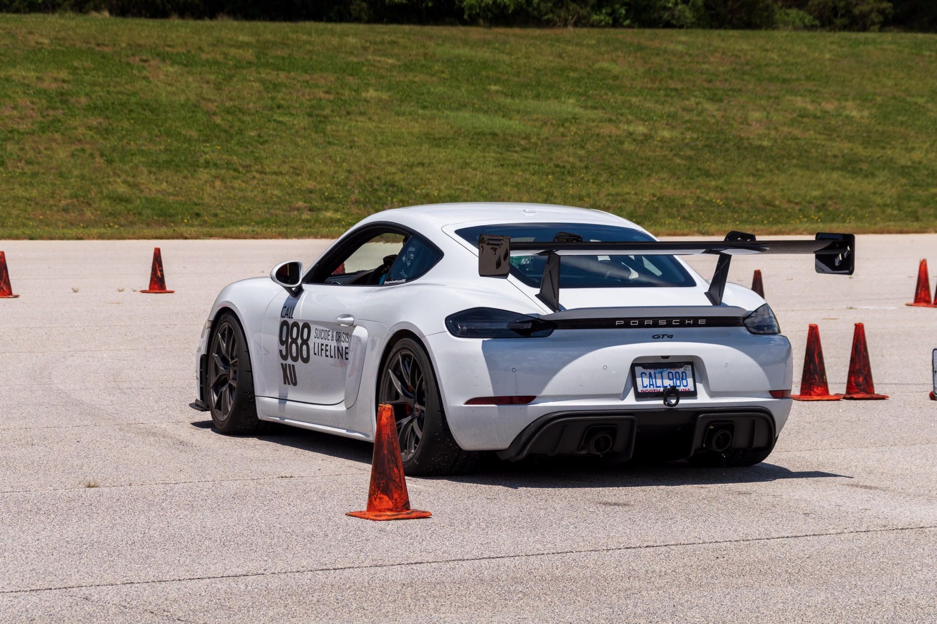 Team Wheelhouse Porsche 718 Cayman GT4 988 rear quarter cornering on autocross course