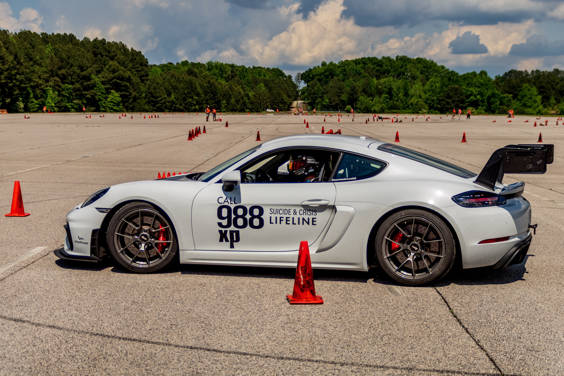 Side view of Cayman GT4 988 straight-line accelerating through a course transition