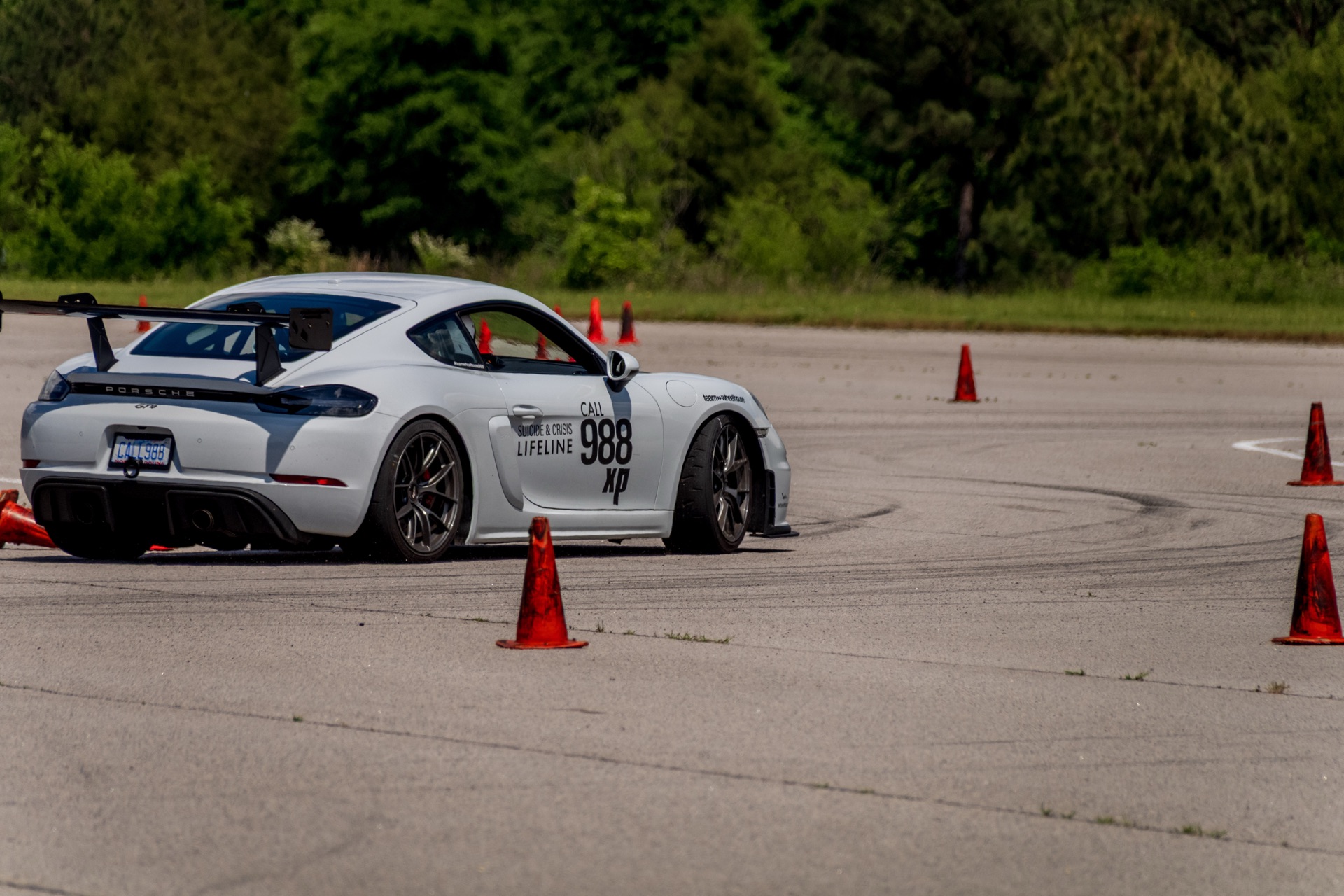 Rear three-quarter of Team Wheelhouse Cayman GT4 988 cornering hard at autocross apex
