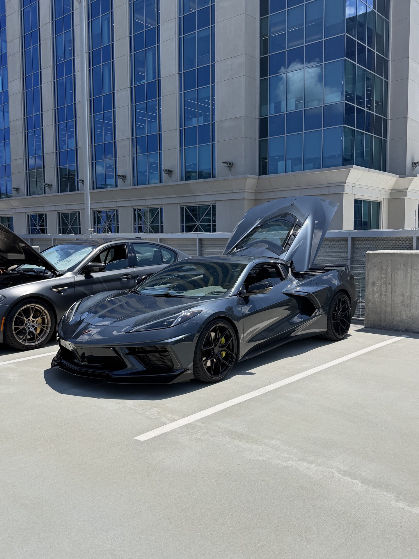 Charcoal grey C8 Chevrolet Corvette with rear hatch raised on the Legacy Union rooftop deck