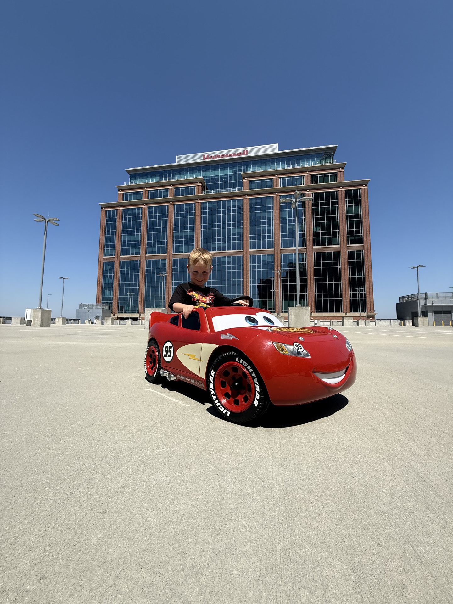 Lightning McQueen ride-on toy car at the Seven20 CLT Meet with the Charlotte skyline behind